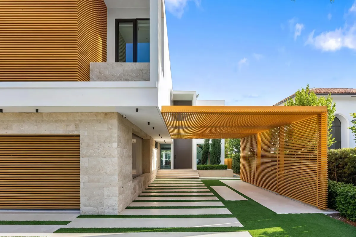 Modern home entrance with white walls, wood cladding and a patterned walkway