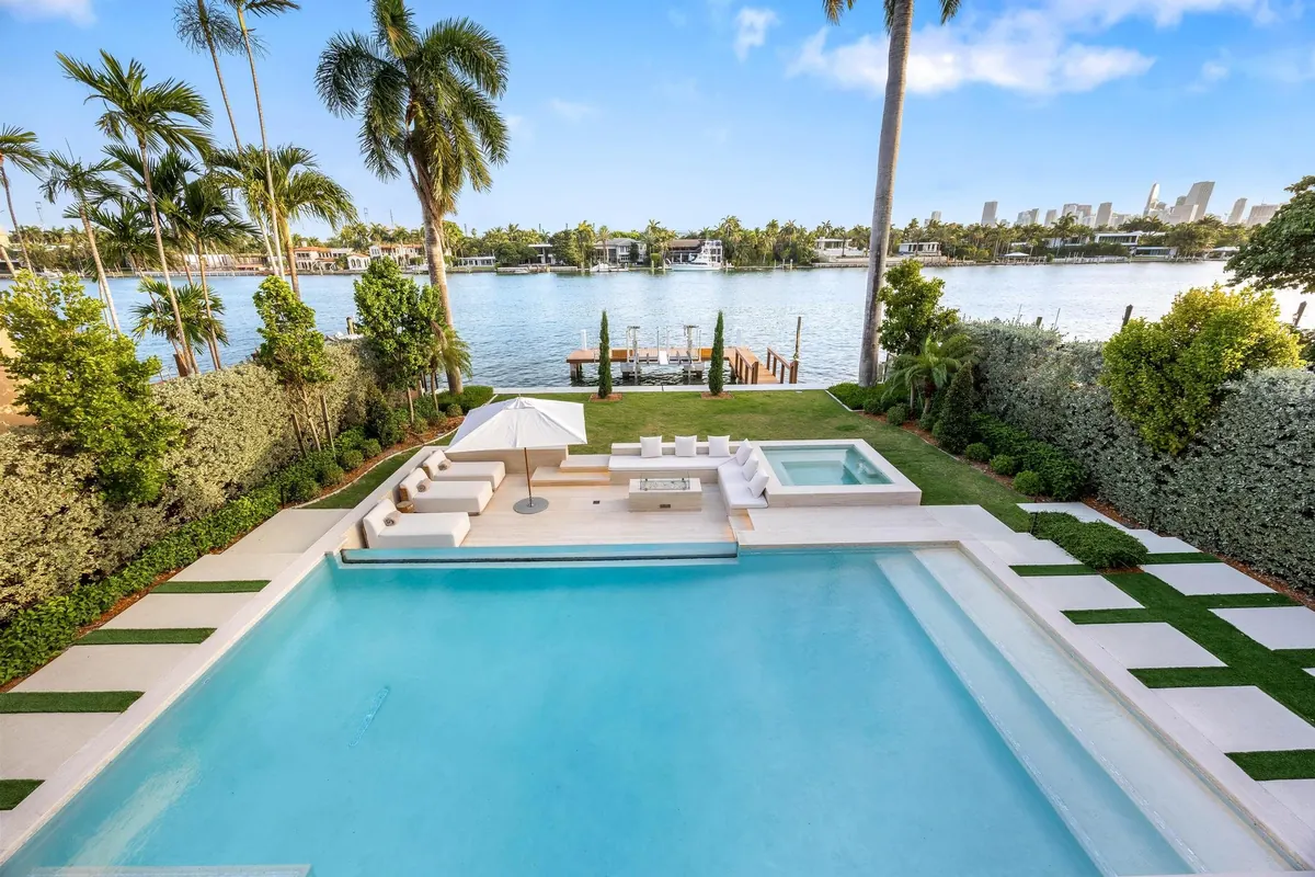 Swimming pool and palm-lined terrace overlooking the water