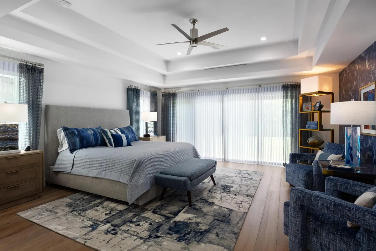 Bright bedroom with a blue-accented bed and wide windows