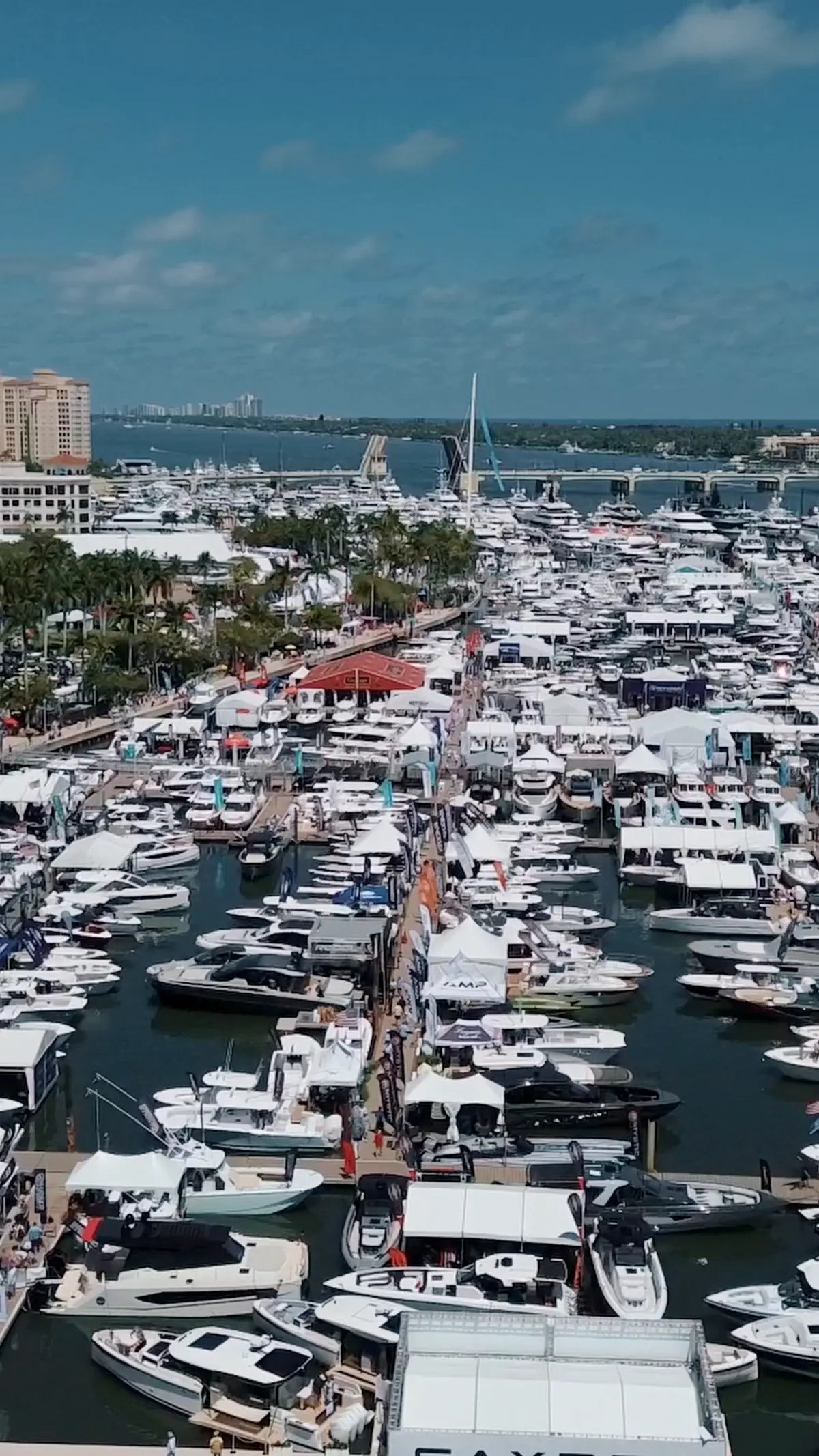 Frame from the boat show film: yachts and visitors along the marina docks