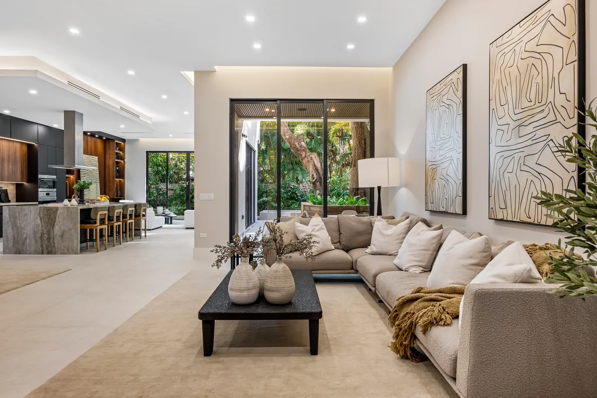 Open living room with a pale sofa, dark coffee table and large garden doors