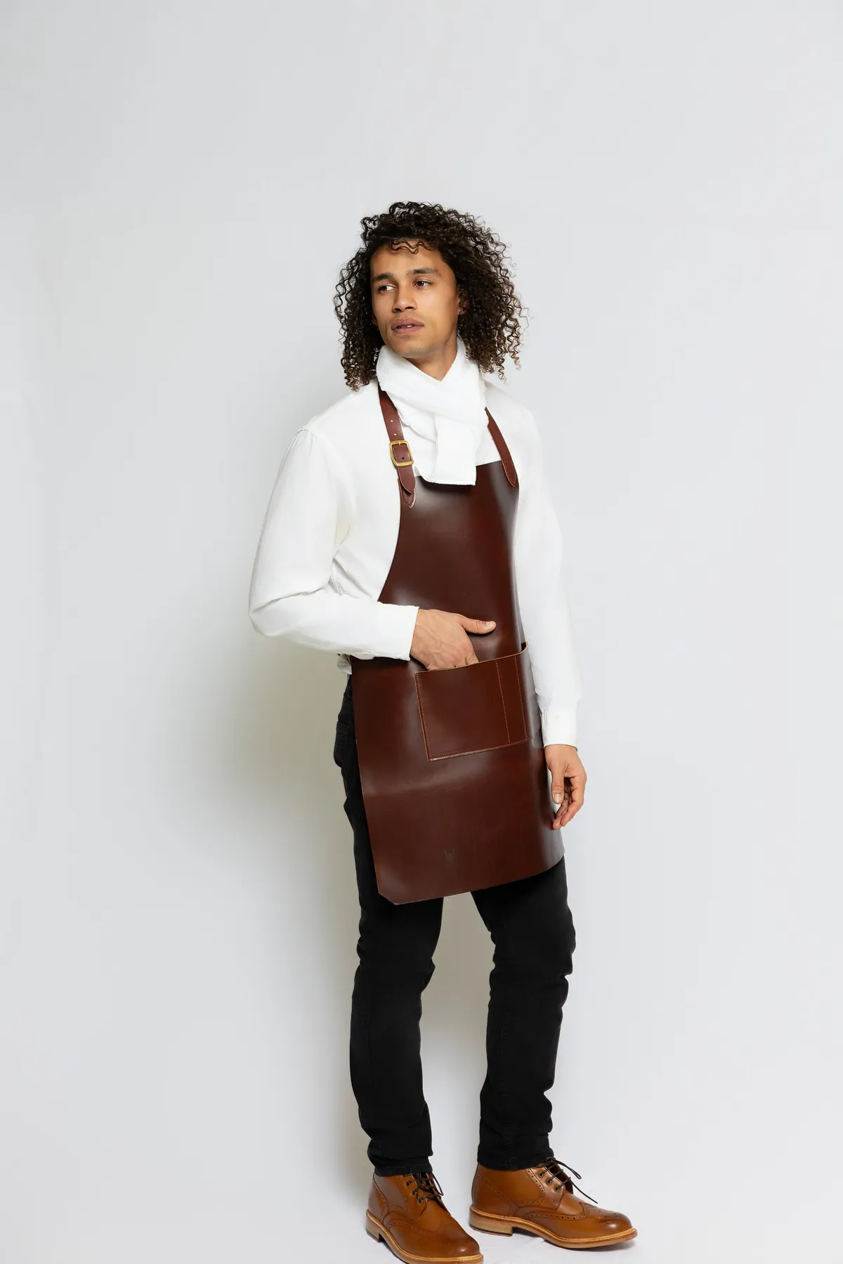 Studio portrait of a model wearing a brown leather apron