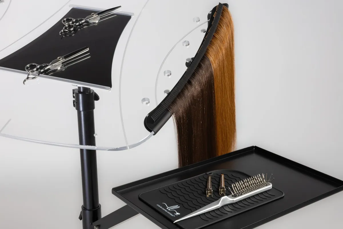 Hair extension display and tools photographed against a pale studio background