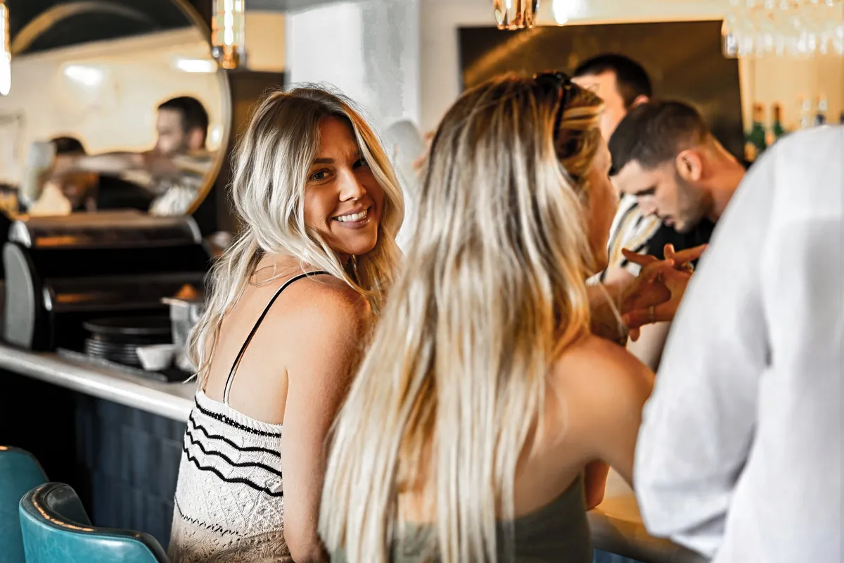 People sharing a conversation at a cafe counter