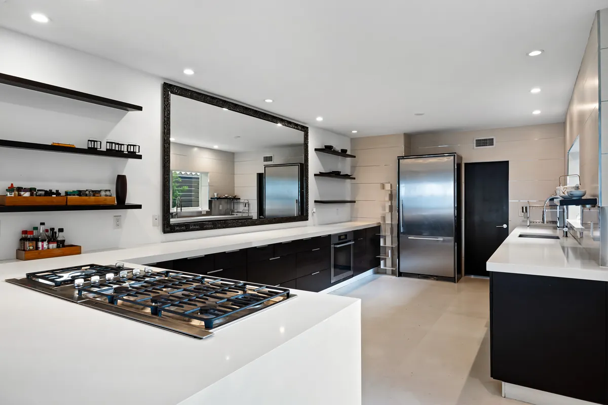 Modern kitchen with pale counters, dark lower cabinets and stainless-steel appliances