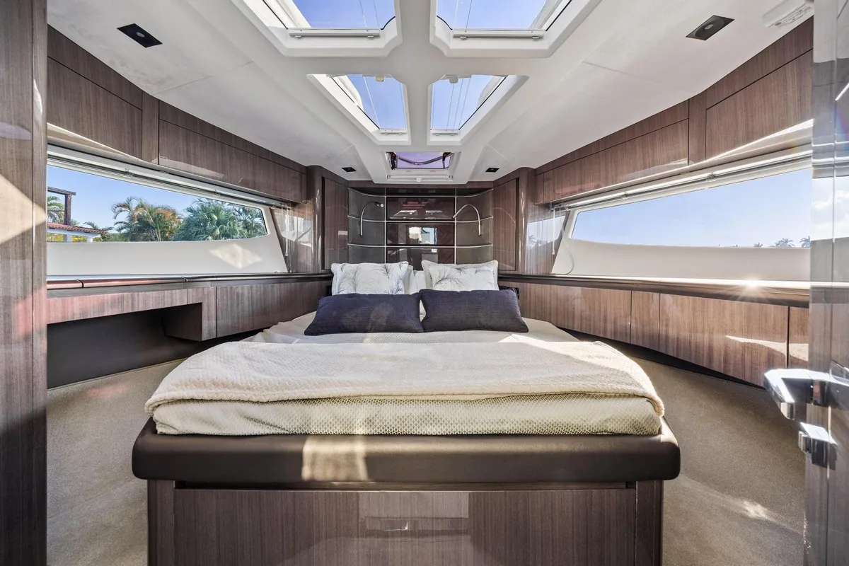 Yacht cabin with a double bed, wood finishes and overhead windows